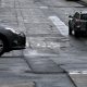 Cars drive on a street with cracked asphalt in San Francisco, California
