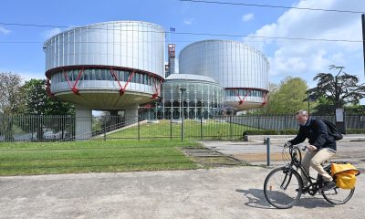 External view of the European Court of Human Rights in Strasbourg, France with a man riding a bicycle in the foreground