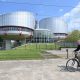External view of the European Court of Human Rights in Strasbourg, France with a man riding a bicycle in the foreground