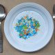 High angle view of microplastics on a single-use plate with fork and spoon on to